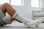 Person wearing white socks with croc wanker on them wearing white Crocs 